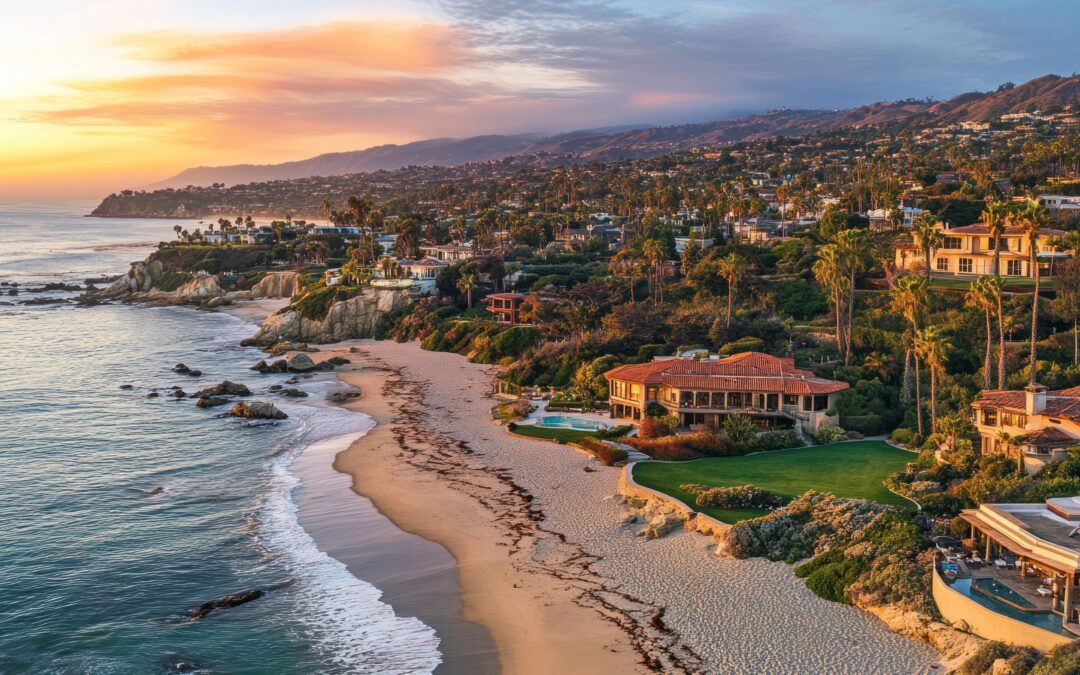 Aerial view of a luxury coastal destination at sunset, featuring high-end resort homes, a winding coastline with cliffs, and ocean waves crashing on the beach.